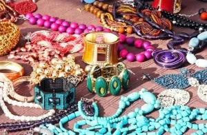 Variety of colorful statement jewelry on a brown cloth.